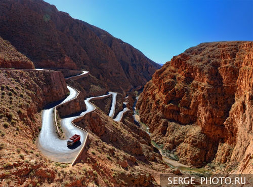 Hairpin in Dades Gorge

Dades Gorge has been cleaved by thousands of years of water erosion. Winter storms blast these mountains every year, flooding the River Dades and gouging out even more rock. At its narrowest point, the gorge is a mere 30 feet wide, but the cliffs above tower to 1600 feet. Fossils of sea creatures have been found embedded the limestone walls, evidencing of a dramatic upheaval of land from the seabed.